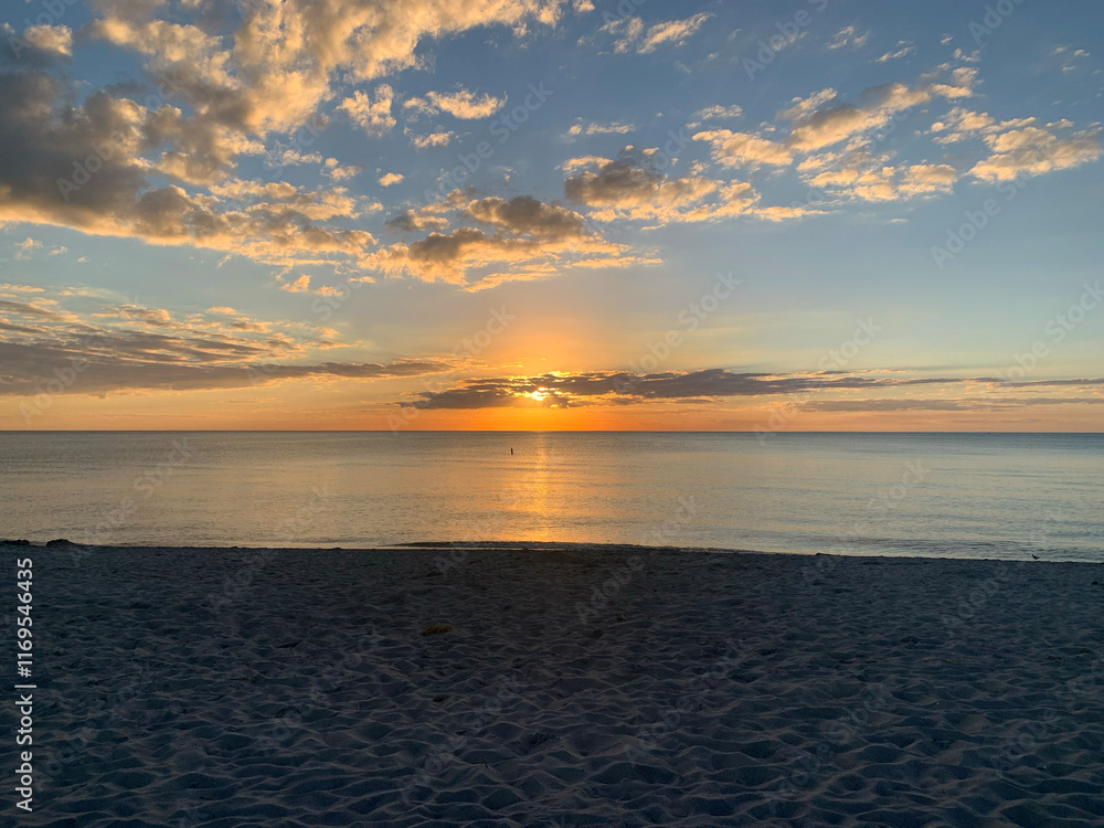 Gulf Coast ocean at sunset with clouds and orange blue sky Gulf Coast ocean at sunset with clouds and orange blue sky