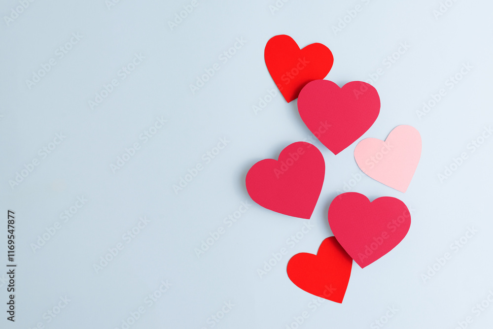 Red paper hearts of various size lying on pastel blue background. Valentines Day, love and feelings concept, top view Red paper hearts of various size lying on pastel blue background. Valentines Day, love and feelings concept, top view