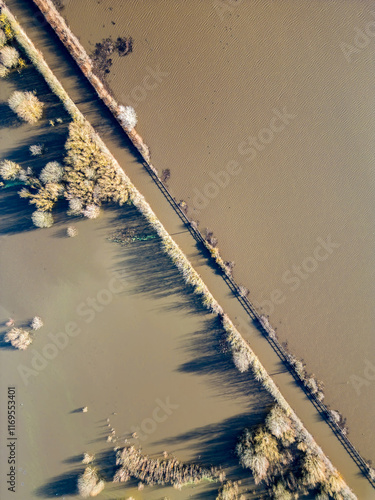 Aerial drone view of flooding from heavy rainfall causes road closures as nearby Fairburn Ings nature reserve floods in West Yorkshire. Agricultural fields and local businesses flooded. photo