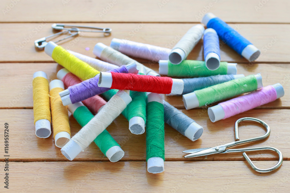 Colorful threads on wooden table.