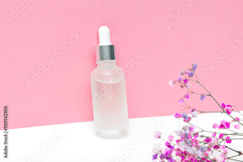 Glass dropper bottle packaging with aromatic oil serum,parfum.Natural organic Spa Cosmetic product design mockup.flat lay,copy space on pink background photo