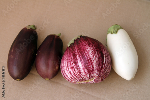 Fresh homegrown purple and white eggplants on the brown paper background  photo