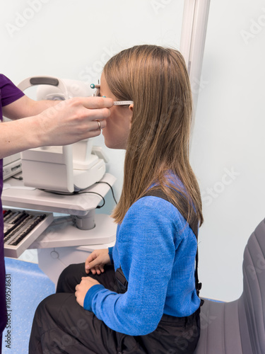 Optometrist performing visual test of child. Examination child with slit lamp. Ophthalmology test of eyes for kids. photo