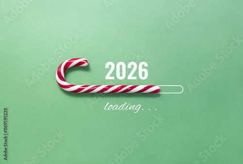 Striped candy cane and lettering 2026 loading on green background. Concept of waiting for seasonal holidays. Copy space, selective focus