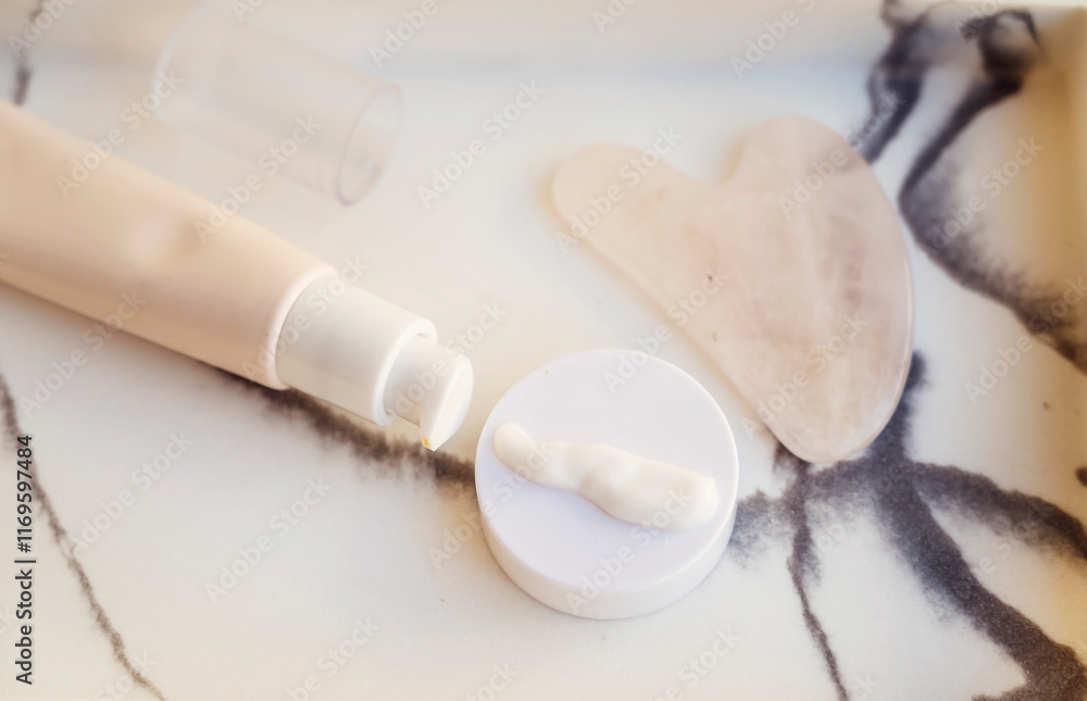Fototapeta premium Anti-Age Eye Cream and Gua Sha Stone in a marble plate