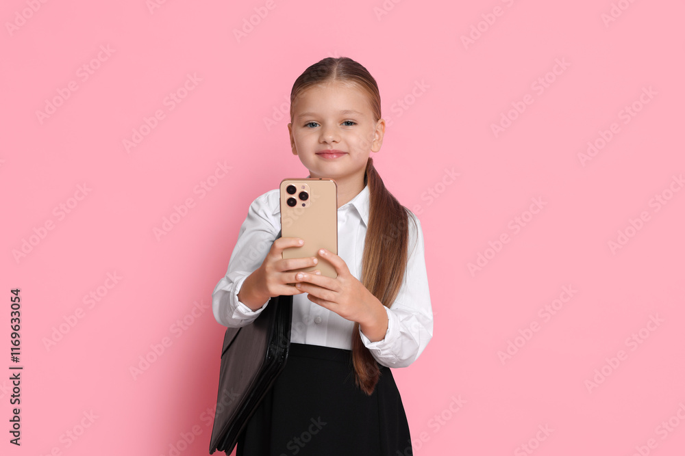 Little girl with briefcase and smartphone pretending to be businesswoman on pink background. Dreaming of future profession Little girl with briefcase and smartphone pretending to be businesswoman on pink background. Dreaming of future profession