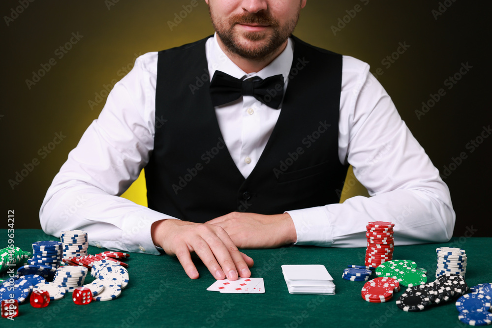Professional croupier at gambling table with playing cards, casino chips and dice, closeup Professional croupier at gambling table with playing cards, casino chips and dice, closeup