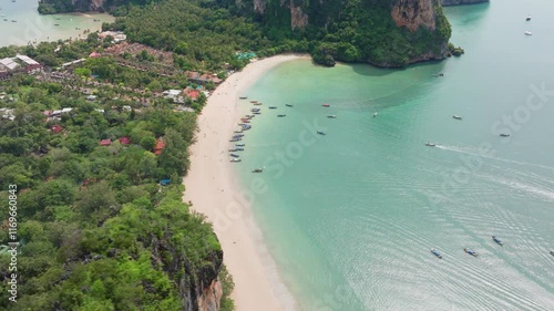 This aerial view highlights Krabis stunning coastline, featuring vibrant longtail boats, lush greenery, and tranquil turquoise waters that showcase Thailands natural beauty photo