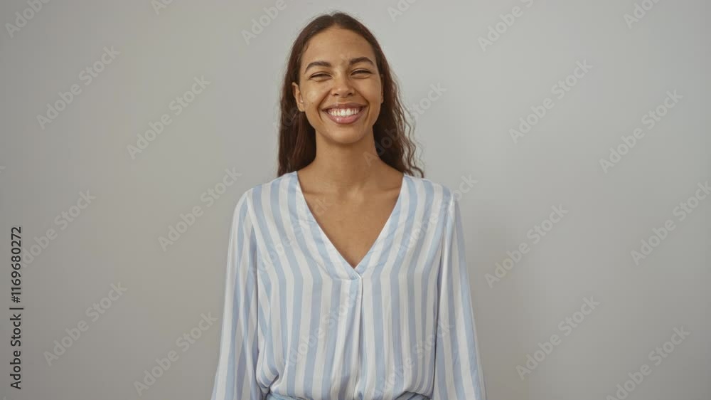 Woman smiling joyfully against a plain background, wearing a striped shirt, depicting confidence and happiness Woman smiling joyfully against a plain background, wearing a striped shirt, depicting confidence and happiness