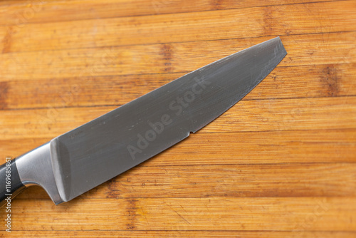 The Broken Kitchen knife on Wooden Cutting Board close up. Selective focus,
