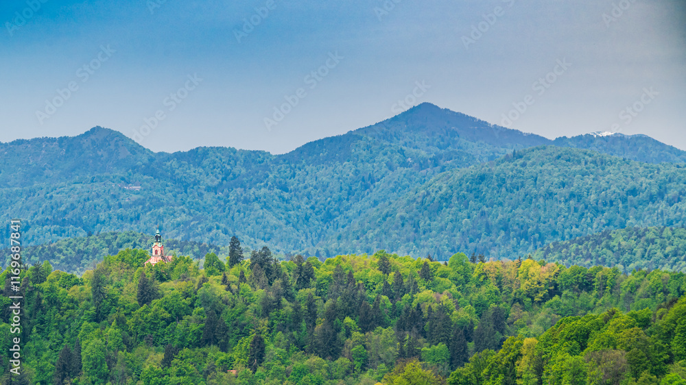 Petite église rose perdue dans une vaste forêt, une grande montagne couverte d'arbres en arrière plan Petite église rose perdue dans une vaste forêt, une grande montagne couverte d'arbres en arrière plan