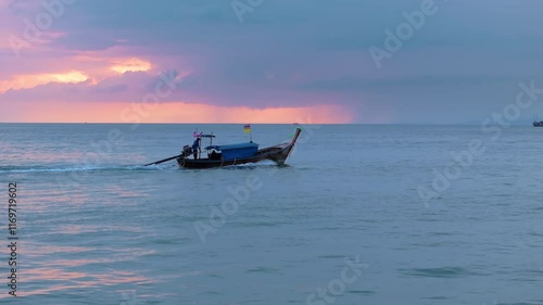 A beautiful scene unfolds as a longtail boat glides through calm waters near Krabis picturesque beach, all beneath a pastel sunset sky, creating a magical moment to cherish photo