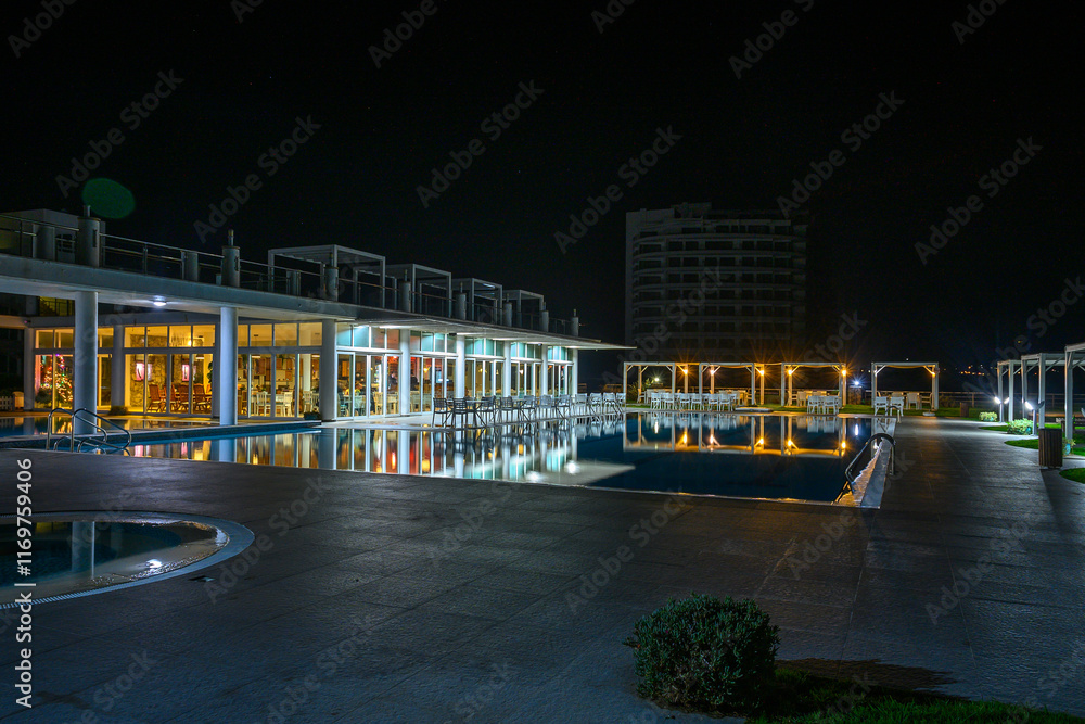 Fototapeta premium Tranquil evening by the poolside with reflections shimmering under the night sky