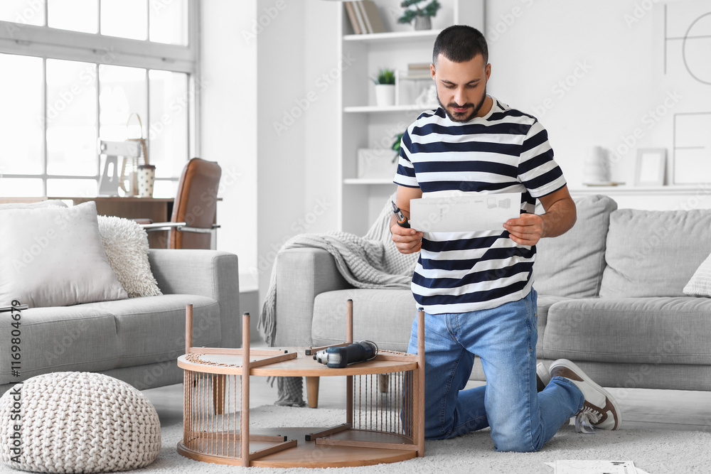 Young man with manual assembling coffee table at home Young man with manual assembling coffee table at home
