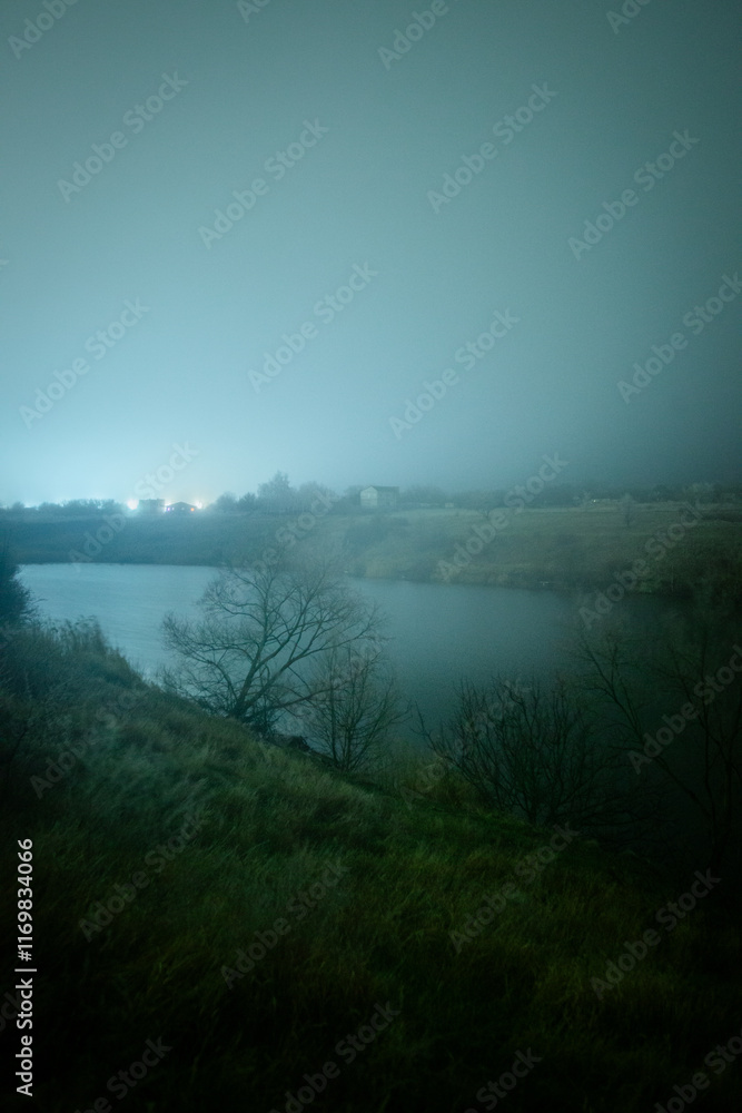 Fototapeta premium Night landscape photography at the winter , beautiful and horor place , wild and beautiful lake around the village cold and frost winter . Houses and cabin in the village at night 