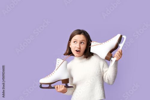 Surprised little girl with ice skates on lilac background