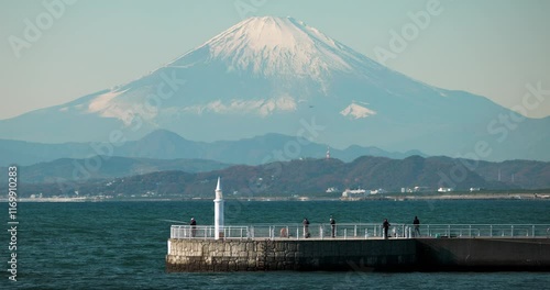 A pier in Sagami Bay with Mount Fuji in the background. People are seen fishing photo