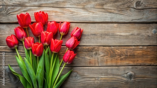A cluster of bright red tulips is scattered across a weathered wooden plank, creating a pop of color against the natural texture of the wood grain , flower arrangement, wildflowers