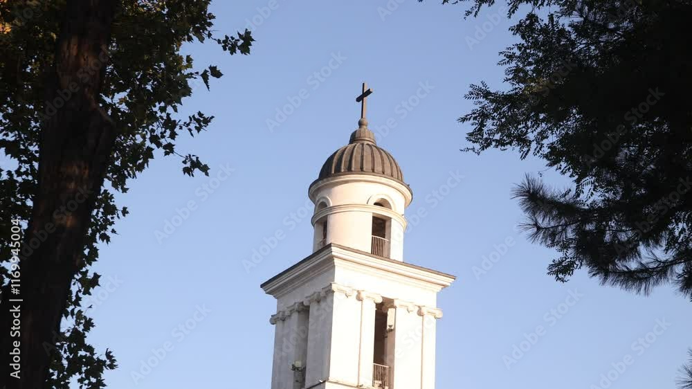 tilt up view of neoclassical Nativity Cathedra nell tower l in Chisinau, Moldova capital city against blue sky with soft warm light tilt up view of neoclassical Nativity Cathedra nell tower l in Chisinau, Moldova capital city against blue sky with soft warm light