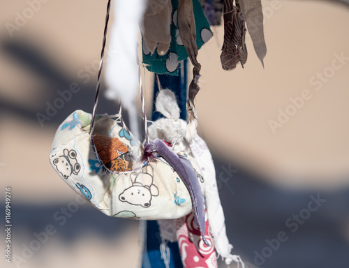 Tiny Handmade Cloth Bassinette Tied Around a Wooden Posts by a Woman Hoping to Conceive photo