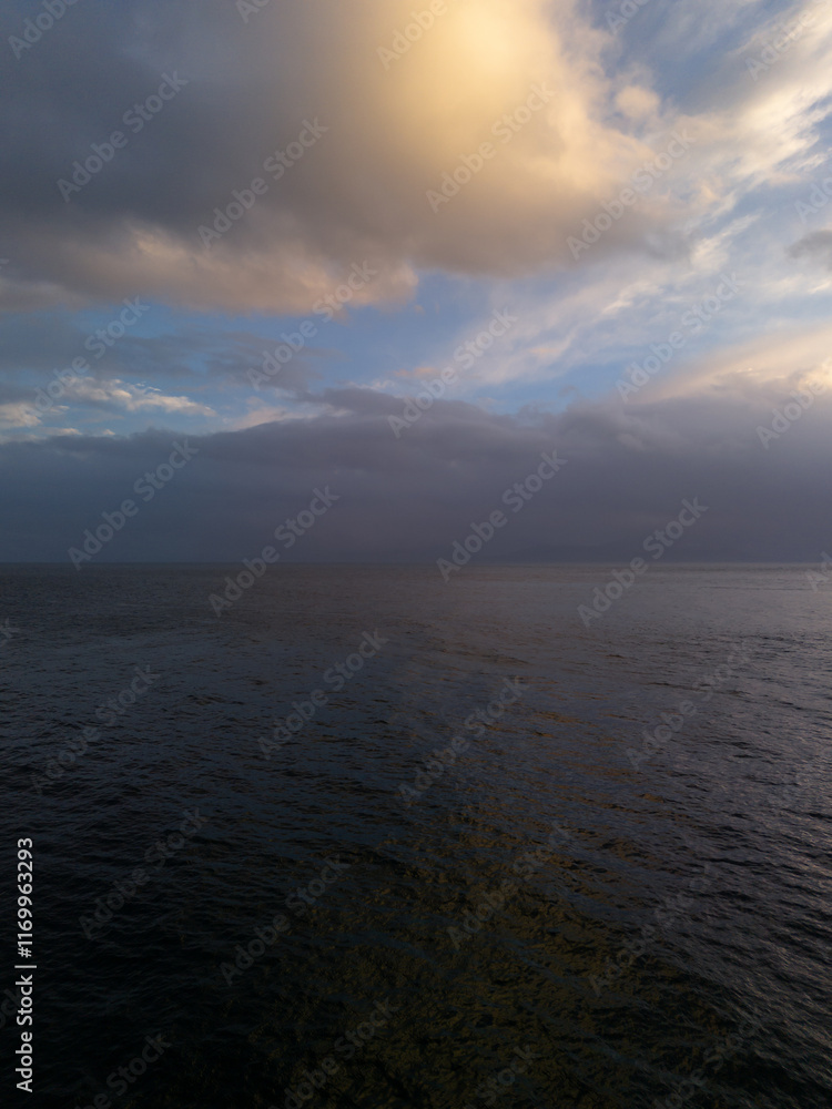 Fototapeta premium Dramatic Sunset Over the Ocean with Clouds and Calm Water