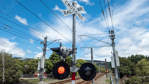 Electric commuter train approaching a crossing in New Zealand