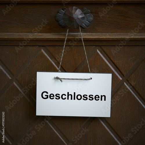 Schild an der Eingangstür zu einem Geschäft mit dem deutschen Wort geschlossen photo