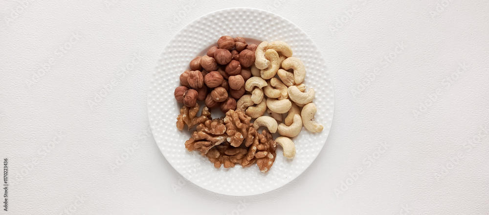Walnuts, cashews, hazelnuts in a plate. Assorted nuts. Protein food. Food with a high protein content. Space for the text. Walnuts, cashews, hazelnuts in a plate. Assorted nuts. Protein food. Food with a high protein content. Space for the text.