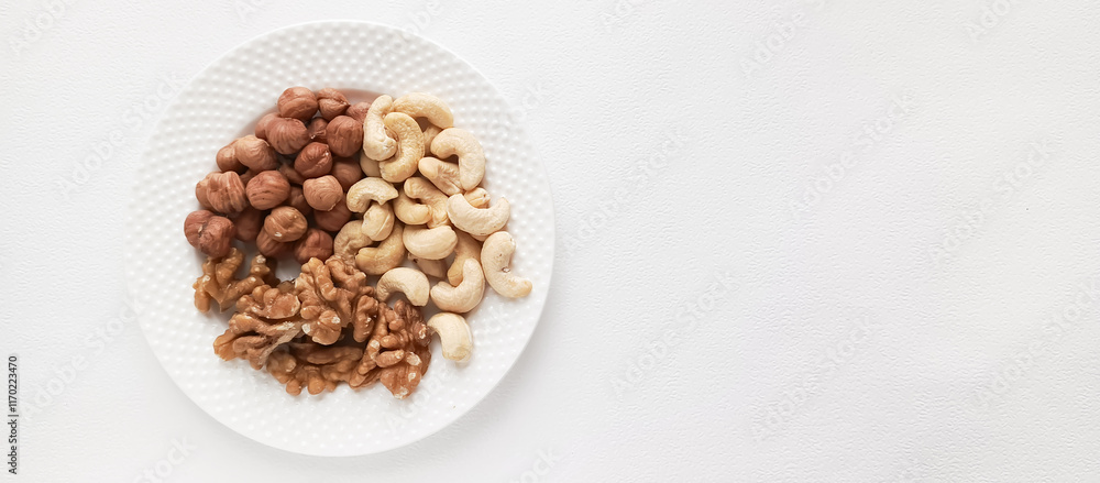 Walnuts, cashews, hazelnuts in a plate. Assorted nuts. Protein food. Food with a high protein content. Space for the text. Walnuts, cashews, hazelnuts in a plate. Assorted nuts. Protein food. Food with a high protein content. Space for the text.