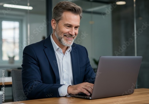 A happy businessman watching a webinar or attending a virtual meeting on his laptop

