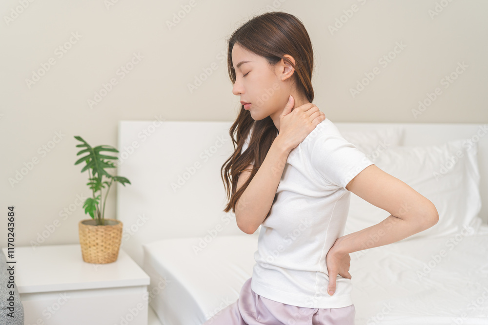 Pain body muscles stiff problem, asian young woman painful with back, neck ache from work hand holding massaging rubbing shoulder hurt, sore sitting on bed in room at home. Health care and medicine. Pain body muscles stiff problem, asian young woman painful with back, neck ache from work hand holding massaging rubbing shoulder hurt, sore sitting on bed in room at home. Health care and medicine.