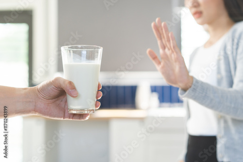 Canvas Print Allergy asian young woman, girl hand in deny, no or push out to avoid for drink milk at home, unhappy and bad stomach ache