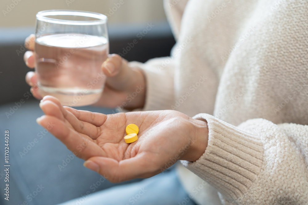 Sick, asian young woman, girl hand holding pill capsule, painkiller medicine from stomach pain, head ache, pain for treatment, take drug or vitamin and glass of water at home, pharmacy and health care Sick, asian young woman, girl hand holding pill capsule, painkiller medicine from stomach pain, head ache, pain for treatment, take drug or vitamin and glass of water at home, pharmacy and health care
