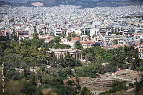 Panoramic view of Athens, Greece, showcasing the ancient Temple of Hephaestus amidst a vibrant cityscape and lush greenery.