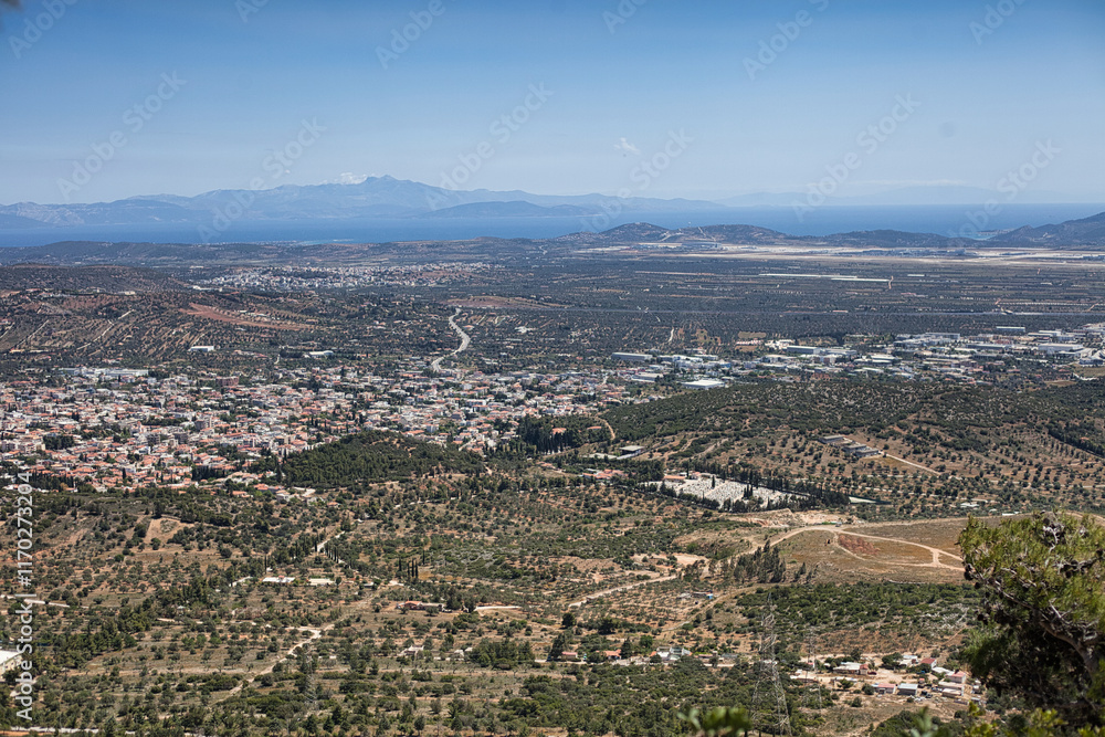 Fototapeta premium Panoramic view of Athens, Greece, showcasing the city's sprawling landscape, the surrounding hills, and the clear blue sky