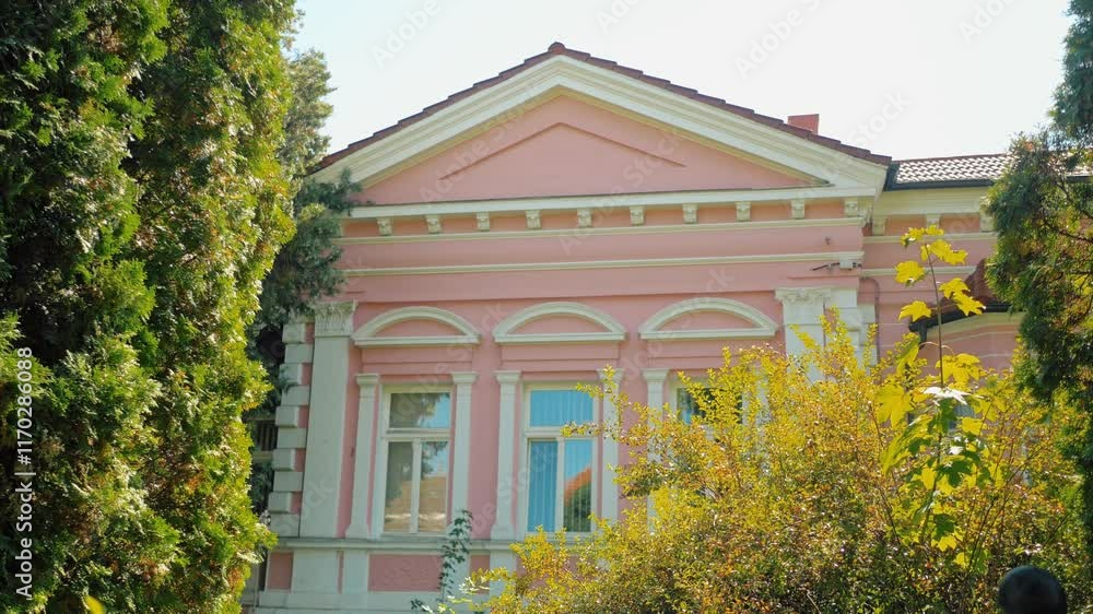 Static shot of an old pink building surrounded by trees Static shot of an old pink building surrounded by trees