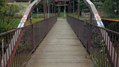 A tilt-up shot of an old amber iron footbridge photo