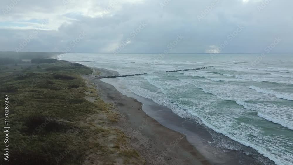Baltic coastline near Nature Park Pape - windy, rainy day, old wooden pier ruins Baltic coastline near Nature Park Pape - windy, rainy day, old wooden pier ruins