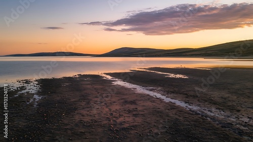 Attractive Aerial beautiful shot of a seashore with hills on the background at sunset photo