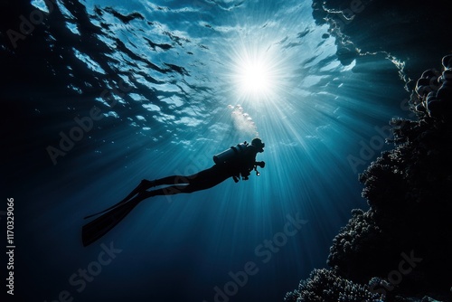 Underwater Silhouette of Diver: Sunbeams Illuminate Ocean Depth photo