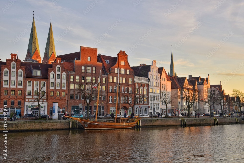Fototapeta premium Architecture of the famous German city of Lubeck along the river at sunset.