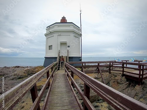 A woman walking to Stirling point lighthouse, Bluff, New Zealand 