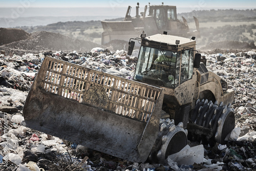Obraz na płótnie Heavy machinery shredding garbage in an open air landfill. Pollution w salonie