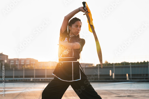 Obraz na plátně Chinese young woman practicing wushu kung fu with weapons outdoor