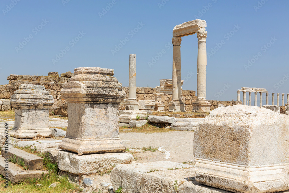 Laodicea archeological site. Ruins of an ancient temple entrance in Laodicea featuring marble columns, stone blocks, and blue sky. Denizli, Turkey (Turliye) Laodicea archeological site. Ruins of an ancient temple entrance in Laodicea featuring marble columns, stone blocks, and blue sky. Denizli, Turkey (Turliye)
