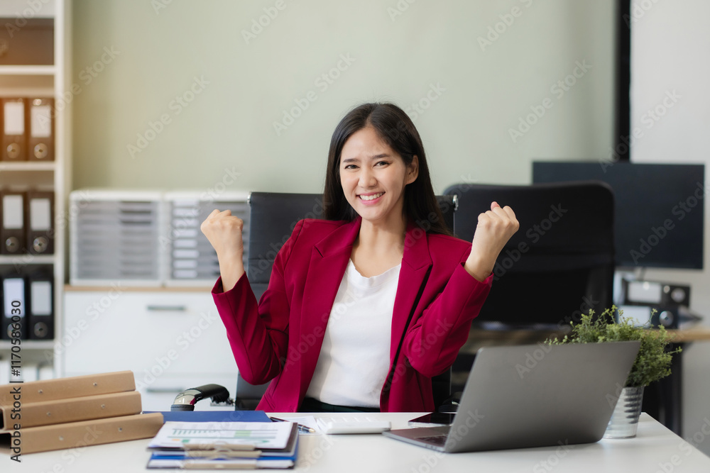 Portrait of a successful business woman with inspiration from their excellent financial results sitting at the desk, looking to camera. Portrait of a successful business woman with inspiration from their excellent financial results sitting at the desk, looking to camera.