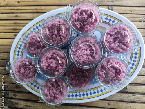 Sticky rice also known as sticky rice ribbon packed in plastic cups on bamboo table mats. photo