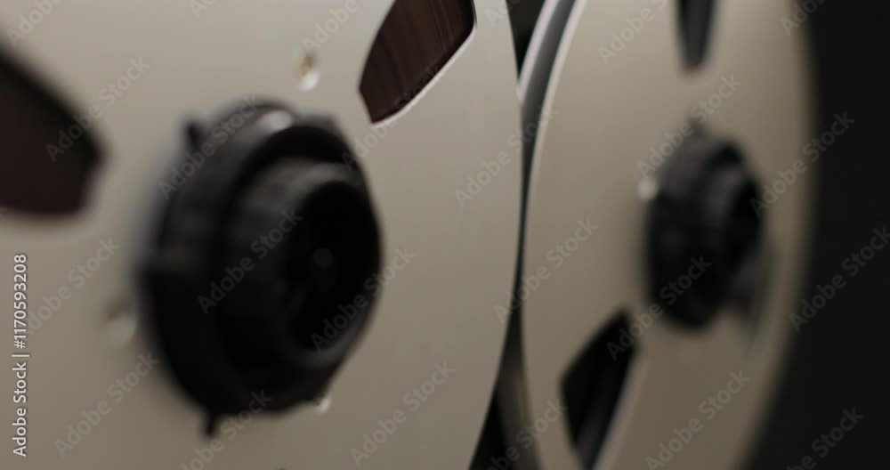 Reel to reel audio recorder tapes spinning. Rotating vintage music player close up. Retro tape. Old school concept. Reel to reel audio recorder tapes spinning. Rotating vintage music player close up. Retro tape. Old school concept.