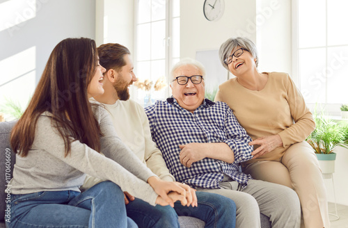 Happy laughing family fun of multi generational relative people at home, mature woman, man close to elderly father, mother, senior parents sitting on sofa enjoy understanding, care, unity support