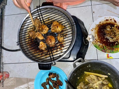 New Year's celebrations, roasting corn, pentol, sausages with friends and family, special stoves and pans for grilling photo